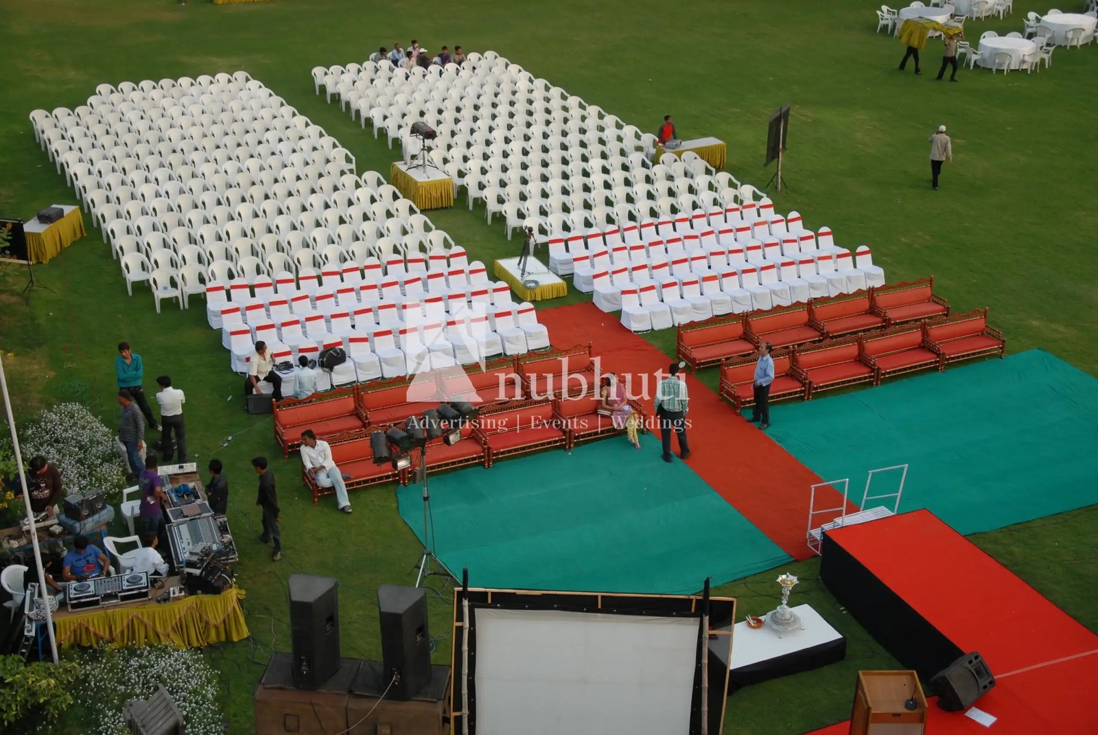 Balloon arch in orange, black, and white colors framing an ITT logo board lit with warm lights